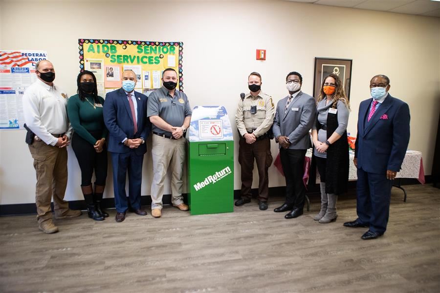 Representatives from AIDB and Local Law enforcement stand around box. 